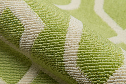 Close-up of a lime green rug with a white striped pattern, 2' x 4', folded.