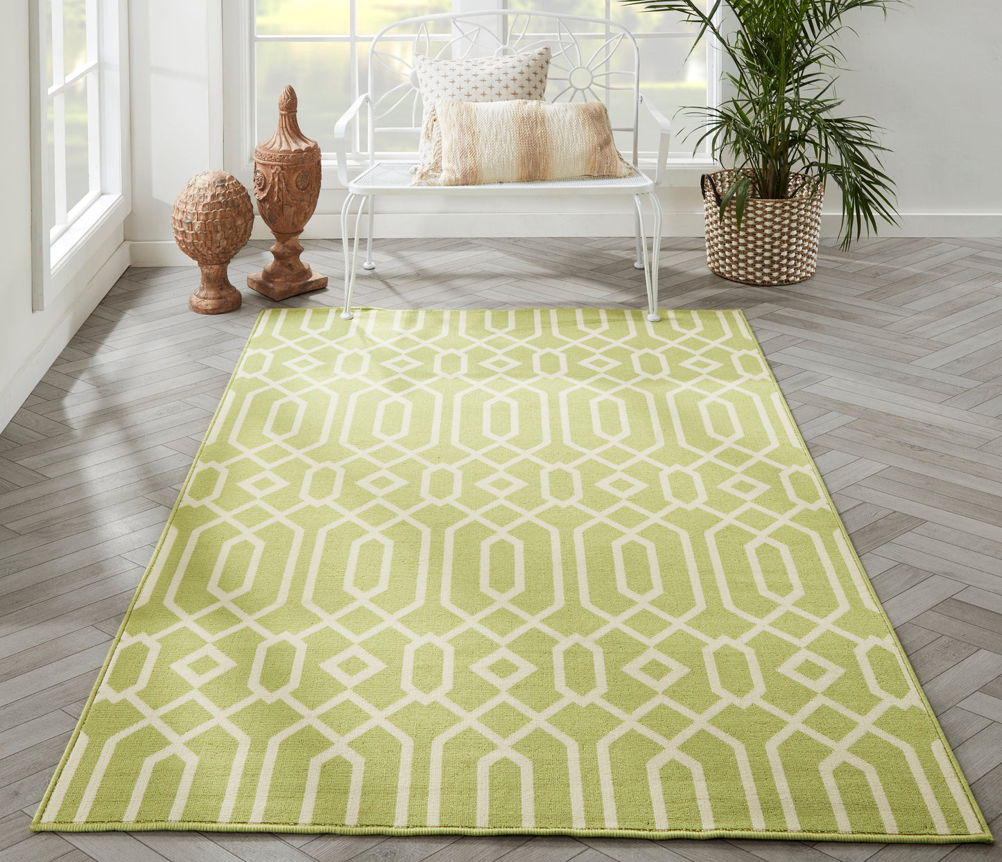 Lime green geometric patterned rug in a bright room with a white bench, beige cushions, and a potted plant.