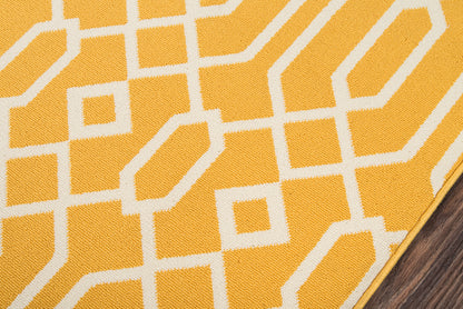Yellow woven rug with white geometric lattice pattern; modern rectangular textile on wood floor.
