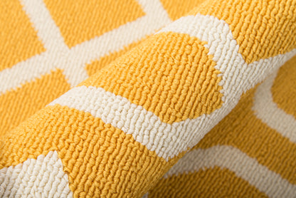 Close-up of yellow rug with white geometric stripes; looped pile texture.
