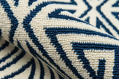 Close-up of a cream and navy blue woven rug with a bold geometric pattern and chunky loop texture.