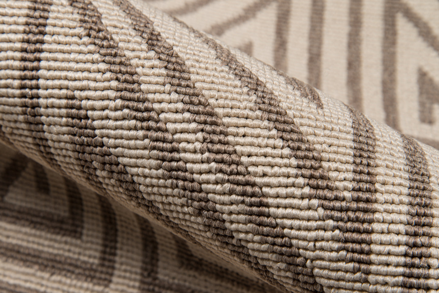 Taupe-beige woven rug with geometric diamond pattern, looped pile & rolled edges.