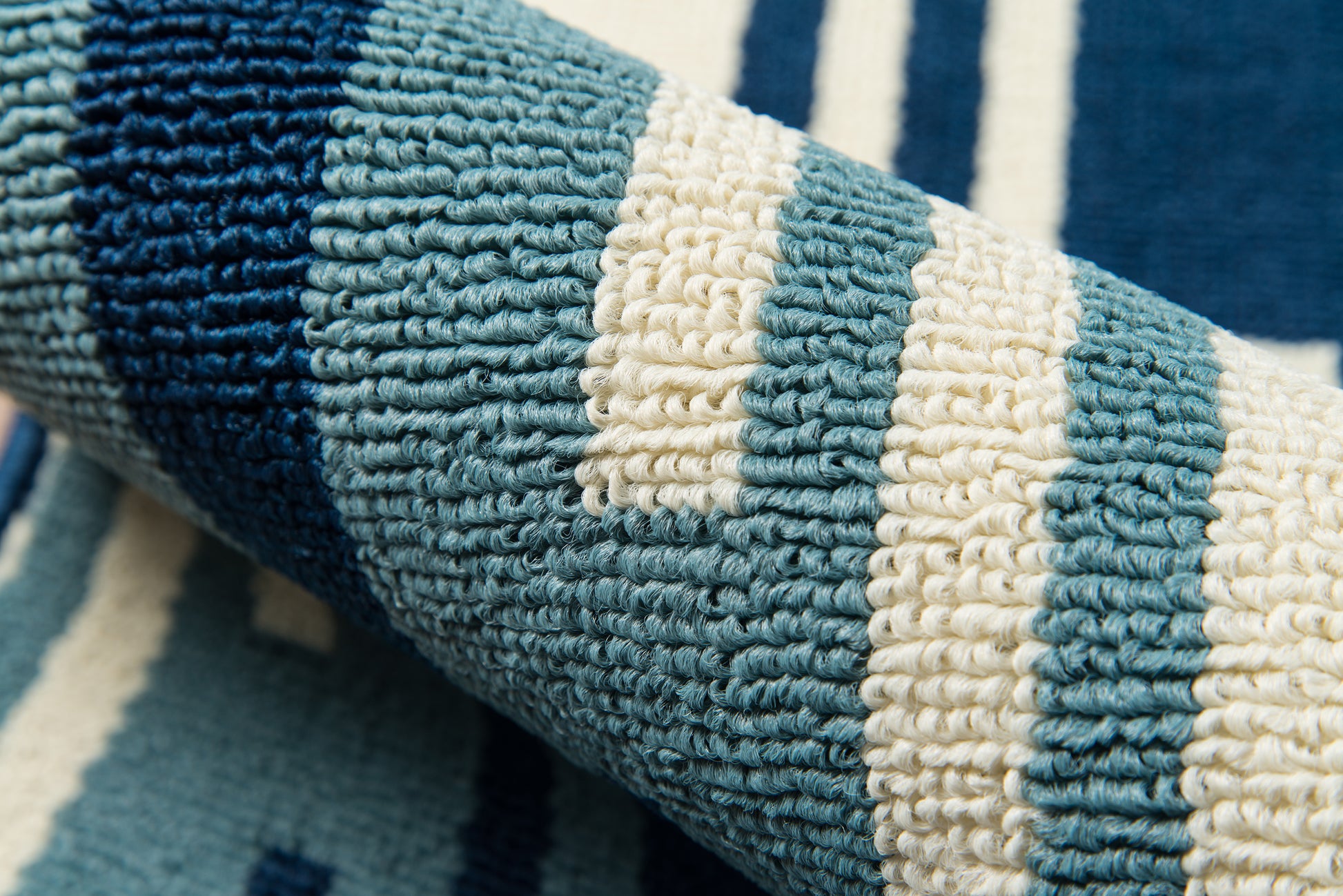 Rolled woven rug in teal, navy & cream stripes; chunky looped texture; decorative rectangular rug.