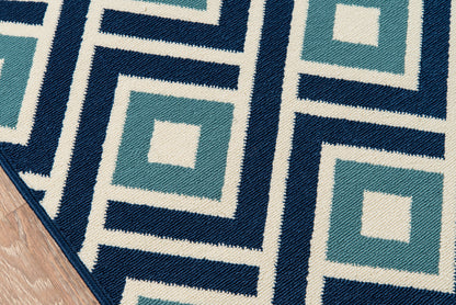 Geometric woven area rug in teal, navy and ivory with square-in-square Greek-key pattern; modern living room rug.