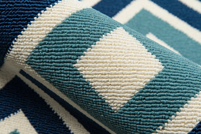 Teal, cream, and navy diamond-patterned woven rug with thick loop pile and geometric motif, 5' x 8'.