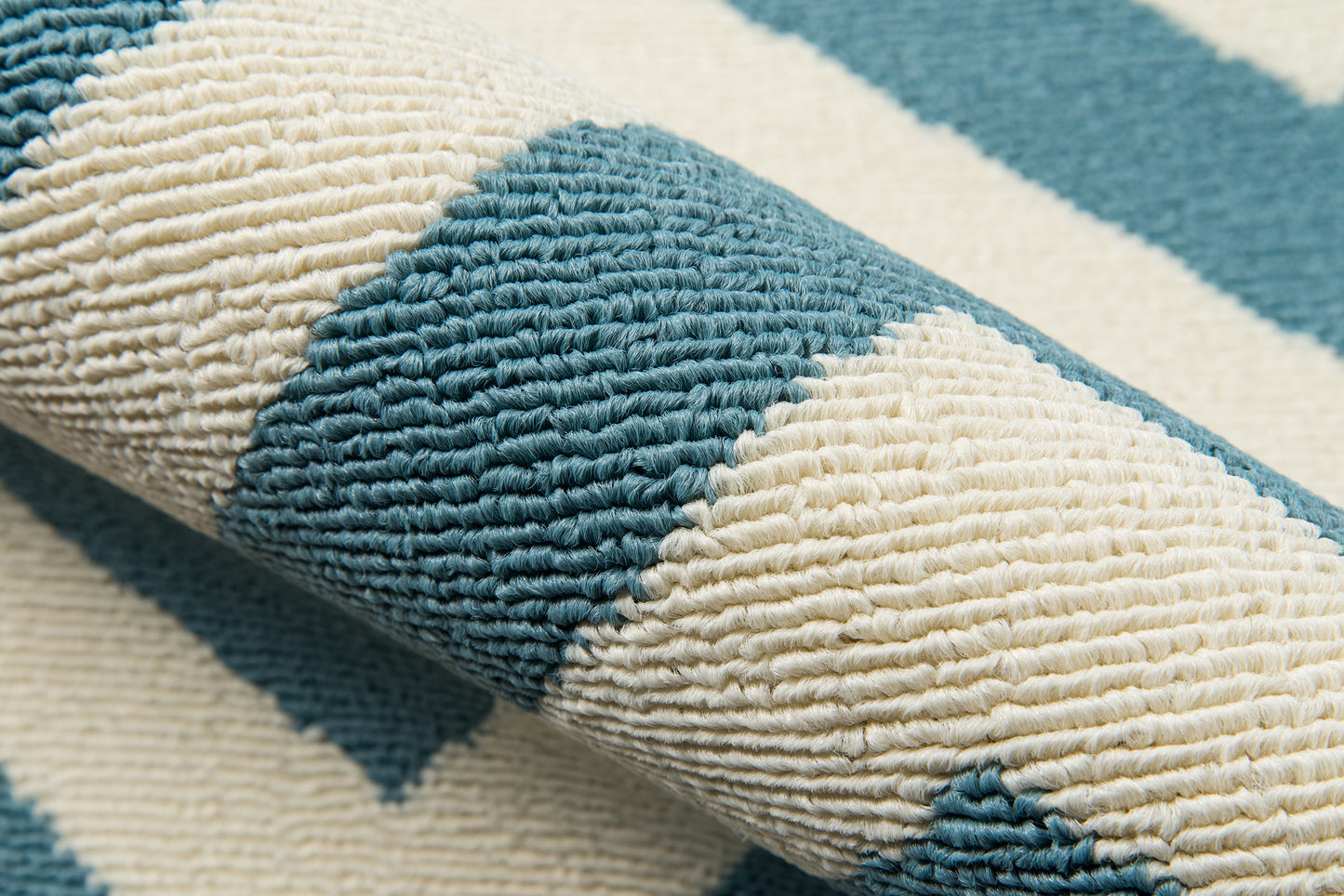 Close-up of a chunky teal and cream striped woven rug with thick loop pile.