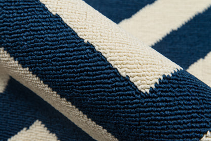 Close-up of a navy and cream zigzag rug with thick looped wool pile.