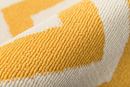 Close-up of mustard yellow and ivory chunky woven rug with cord texture and geometric stripe.