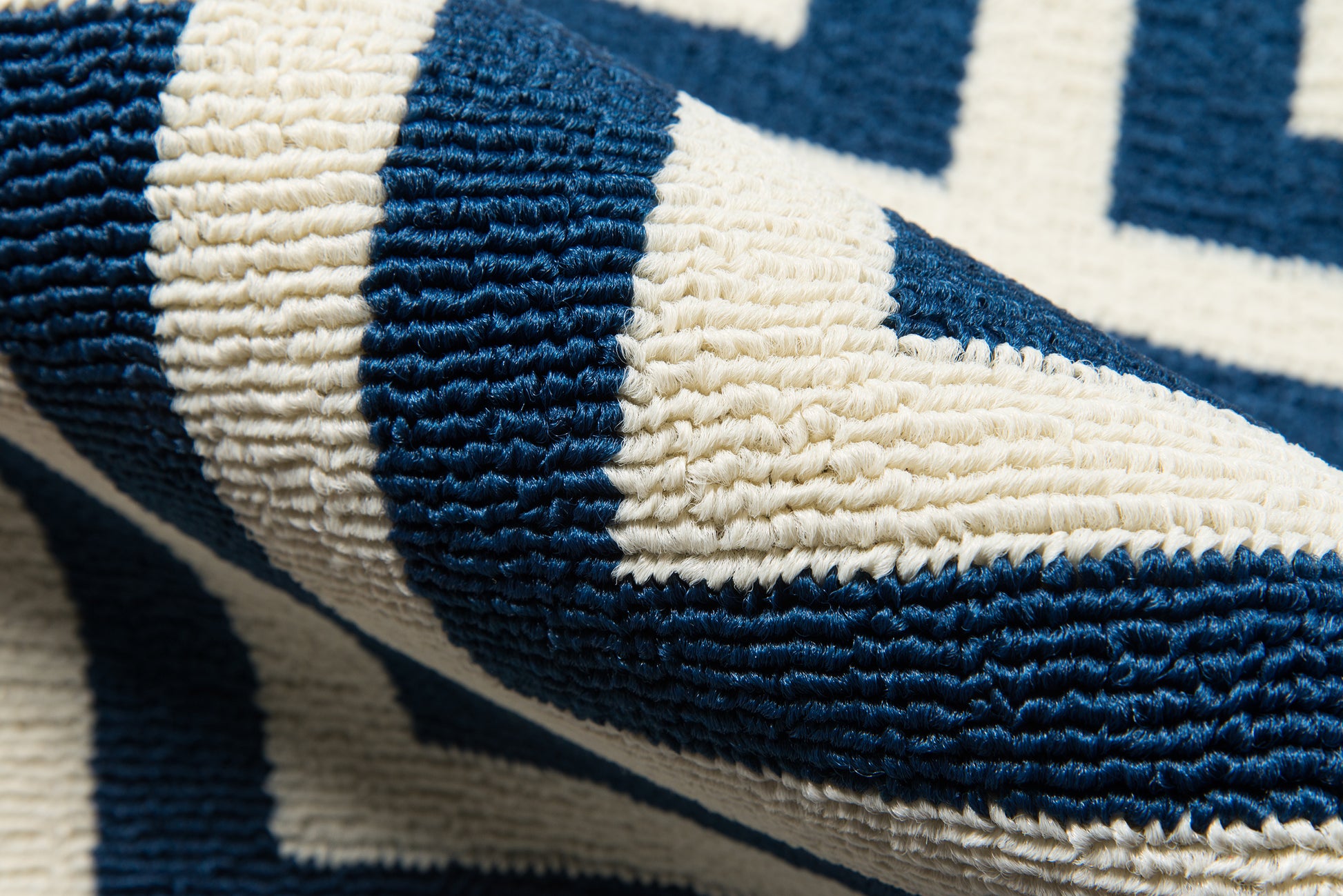 Close-up of navy and cream chevron woven textile with thick terry loops; rug.