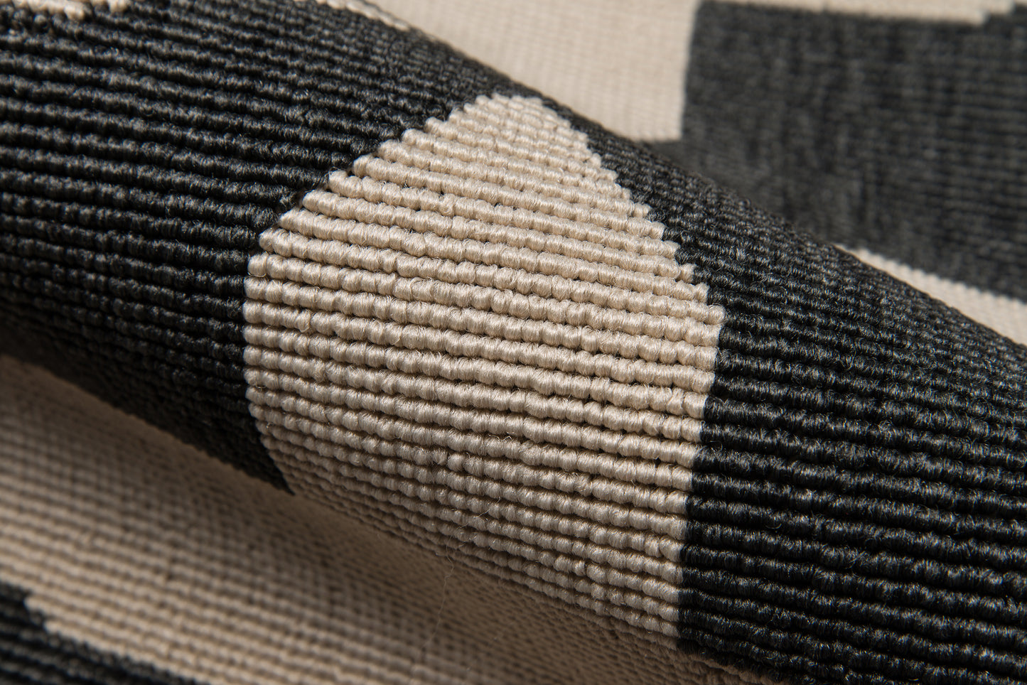 Close-up of black & beige geometric woven rug with chunky ribbed texture.