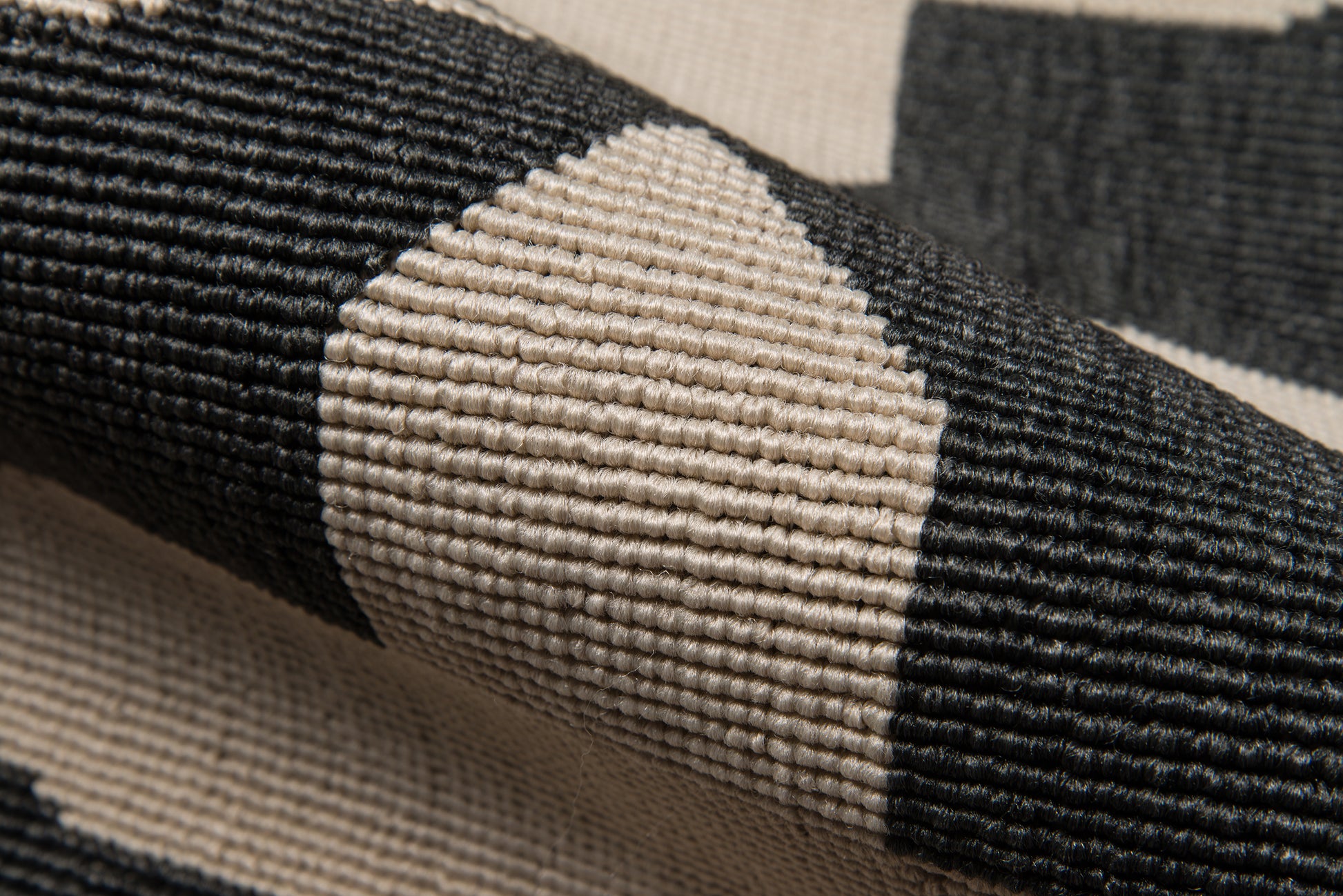 Close-up of black & beige geometric woven rug with chunky ribbed texture.