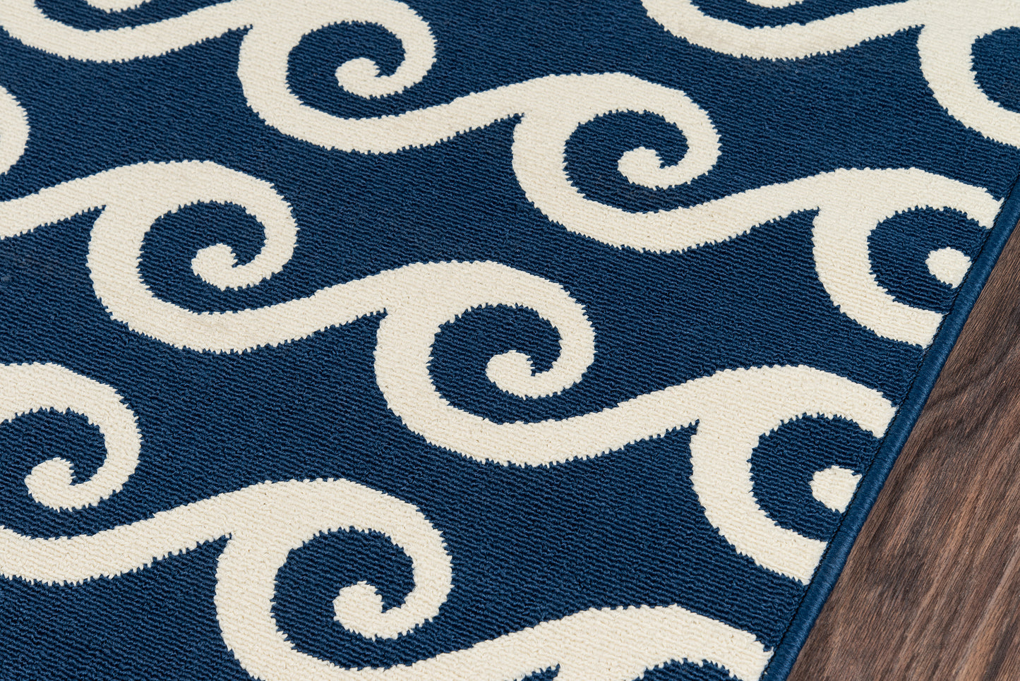 Baja navy rug with white spiral wave motif, woven texture, blue edge binding; ideal for living room decor.