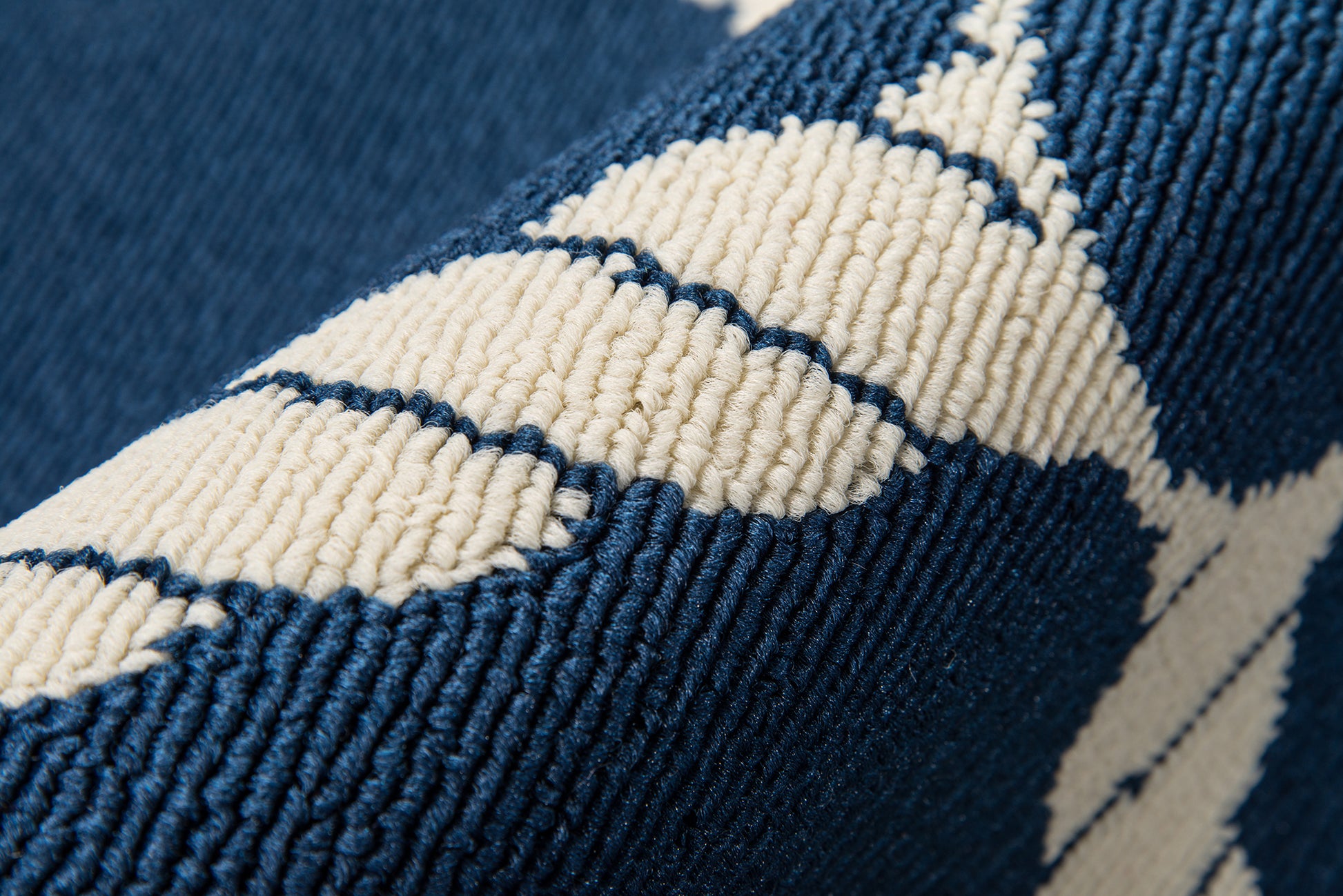 Close-up of blue denim fabric with white chevron pattern and chunky woven texture