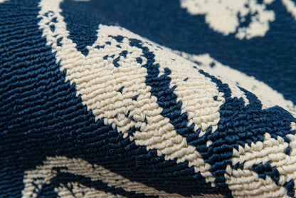 Navy blue woven rug with ivory geometric floral motif and thick boucle yarn; 2' x 4'.