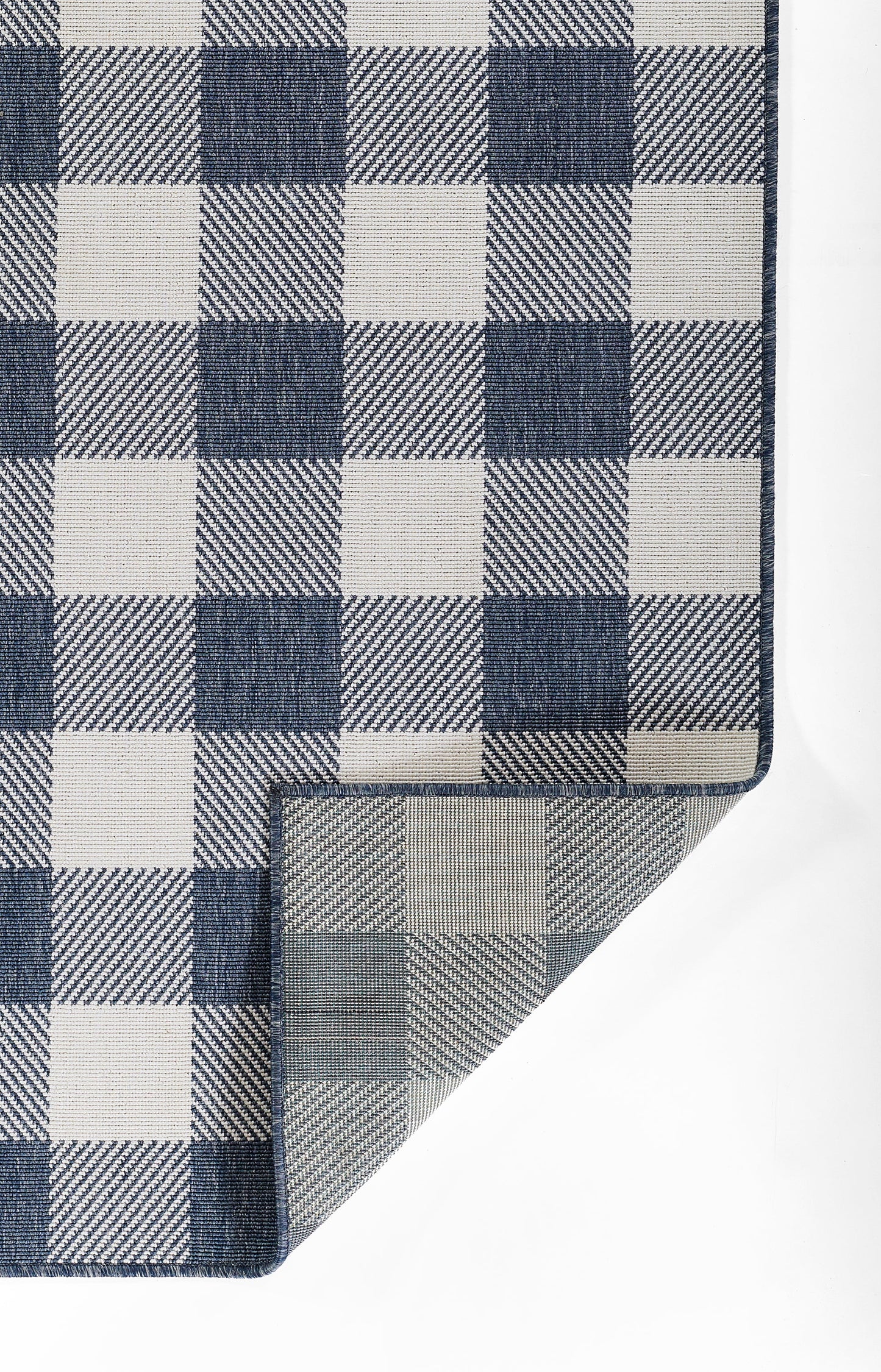 Navy blue and white gingham rug with a folded corner.