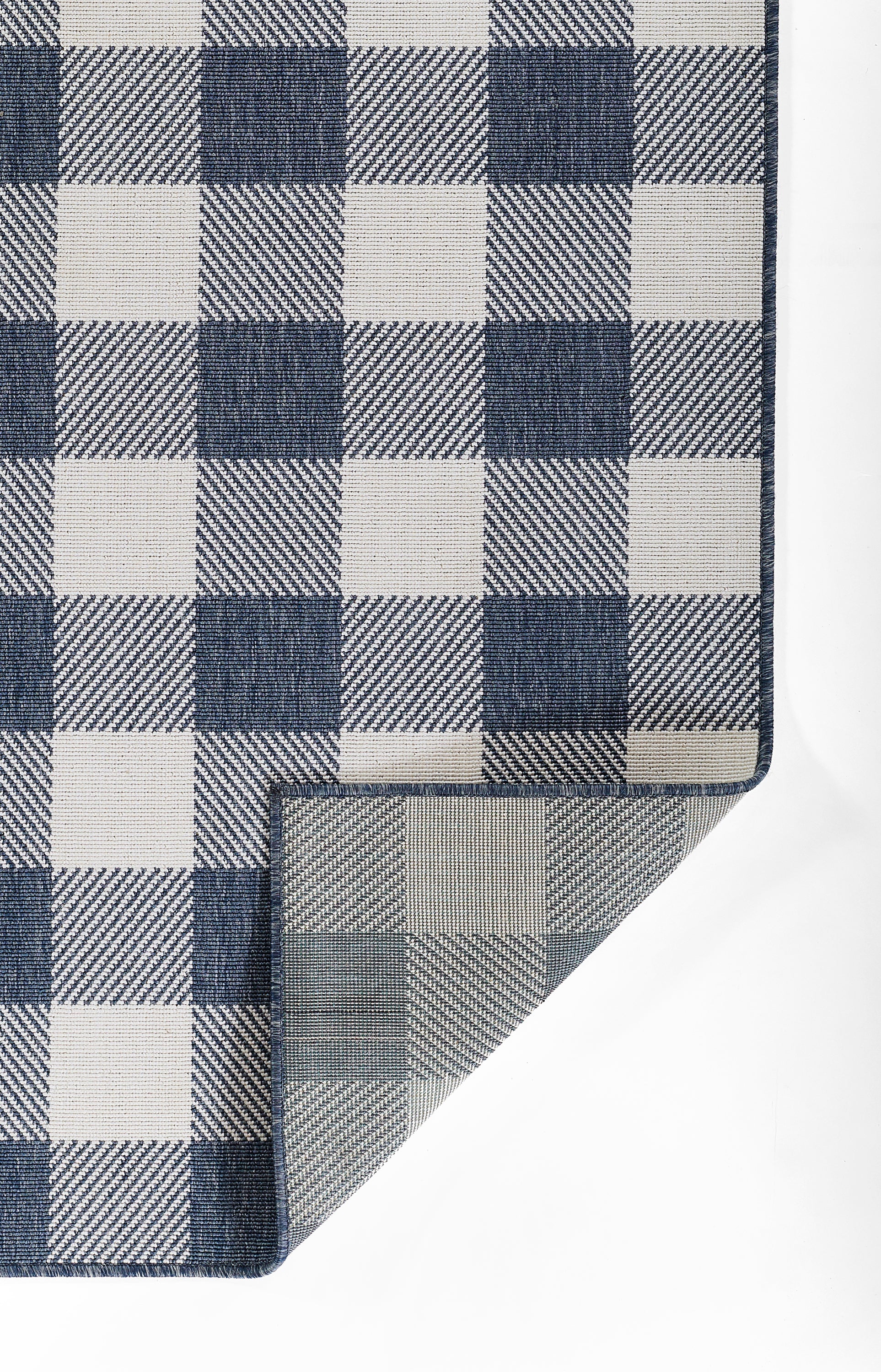Navy blue and white gingham rug with a folded corner.