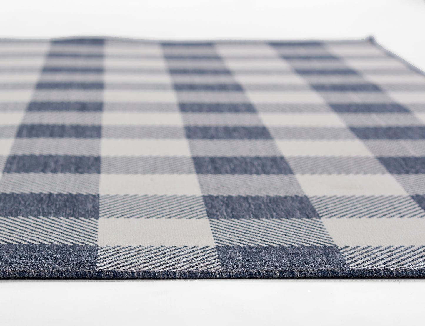Blue & white plaid woven rug with large checker squares; textured textile.