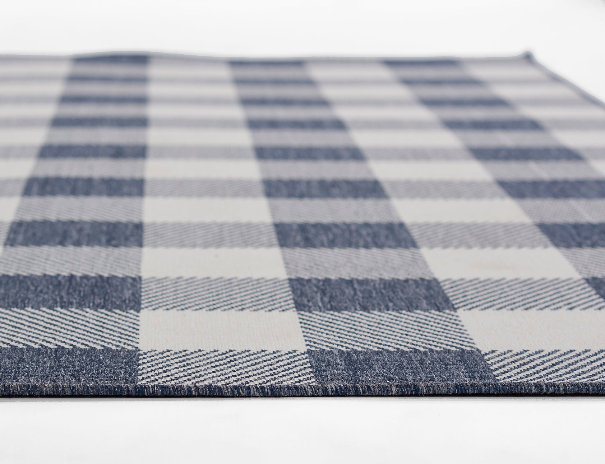 Blue & white plaid woven rug with large checker squares; textured textile.