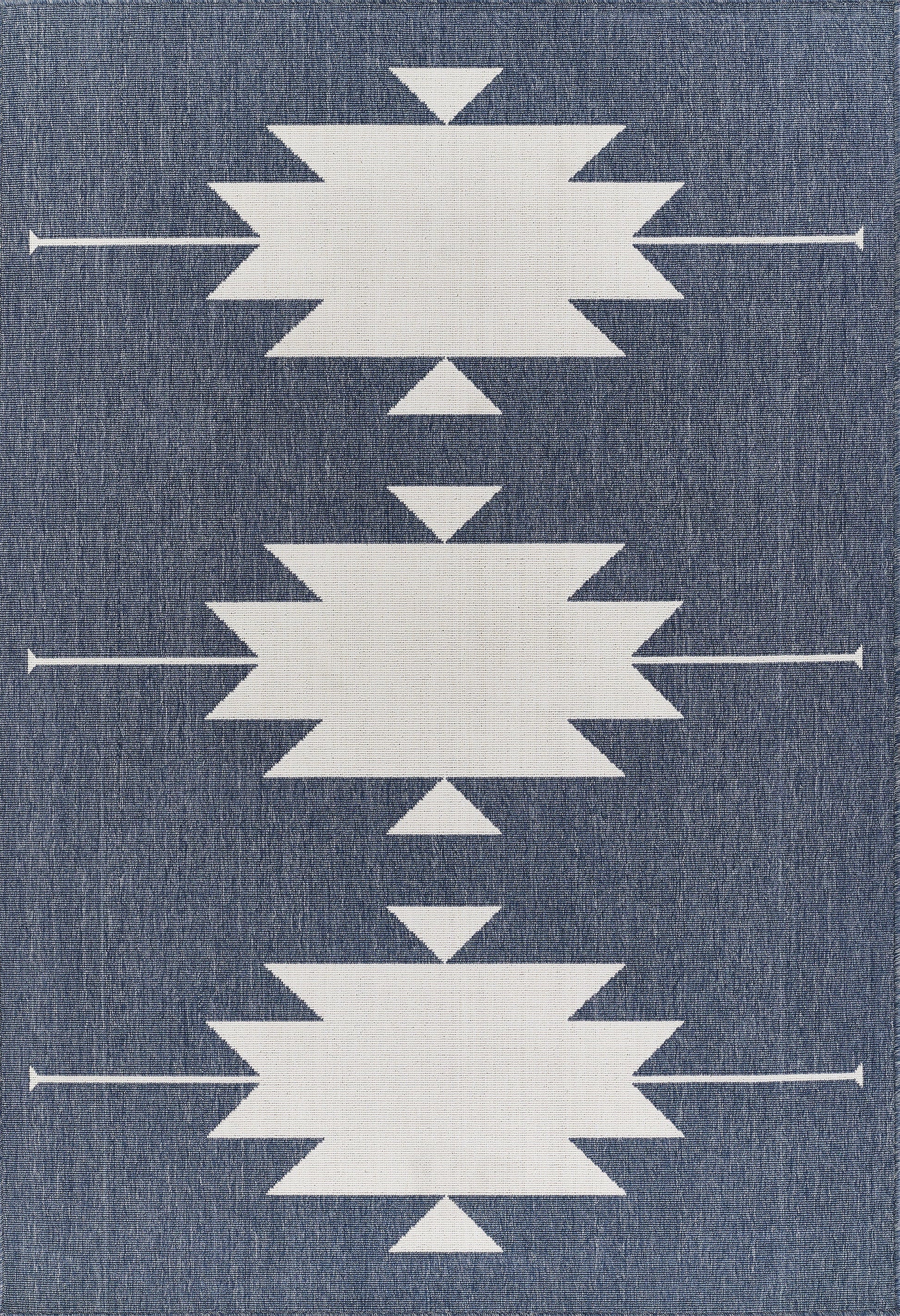 Denim-blue rug with three large white starburst shapes and small triangles, arranged in a vertical pattern.