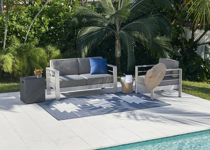 Modern gray outdoor sofa and chair set with cushions, blue pillow, beige cushion, gray ottoman, blue geometric rug by pool