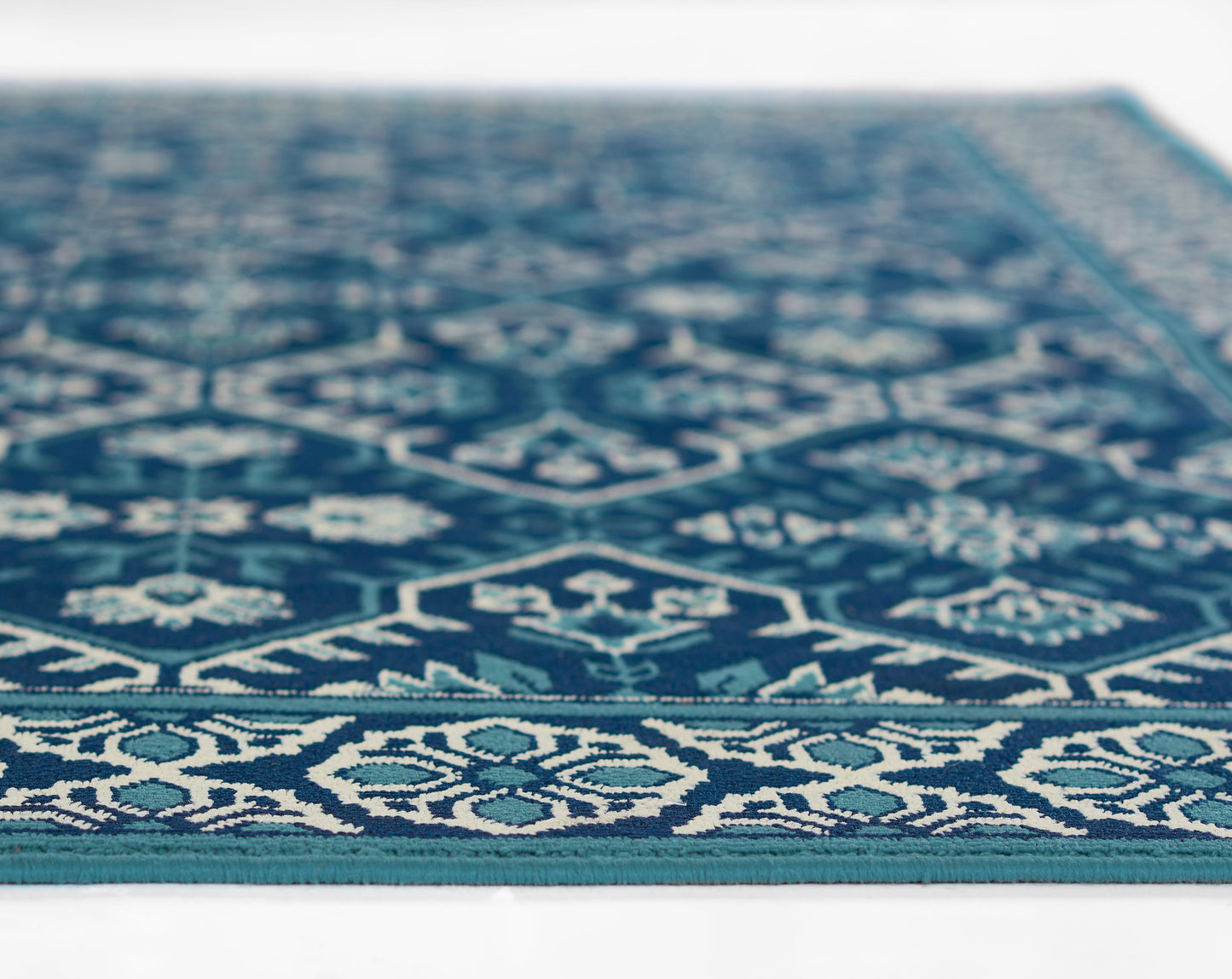 Blue kilim-style rug with white geometric motifs and teal border, flat-weave.