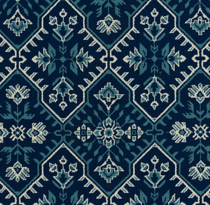 Woven rug with a tile-like diamond pattern in teal & navy, featuring light blue/white floral accents.