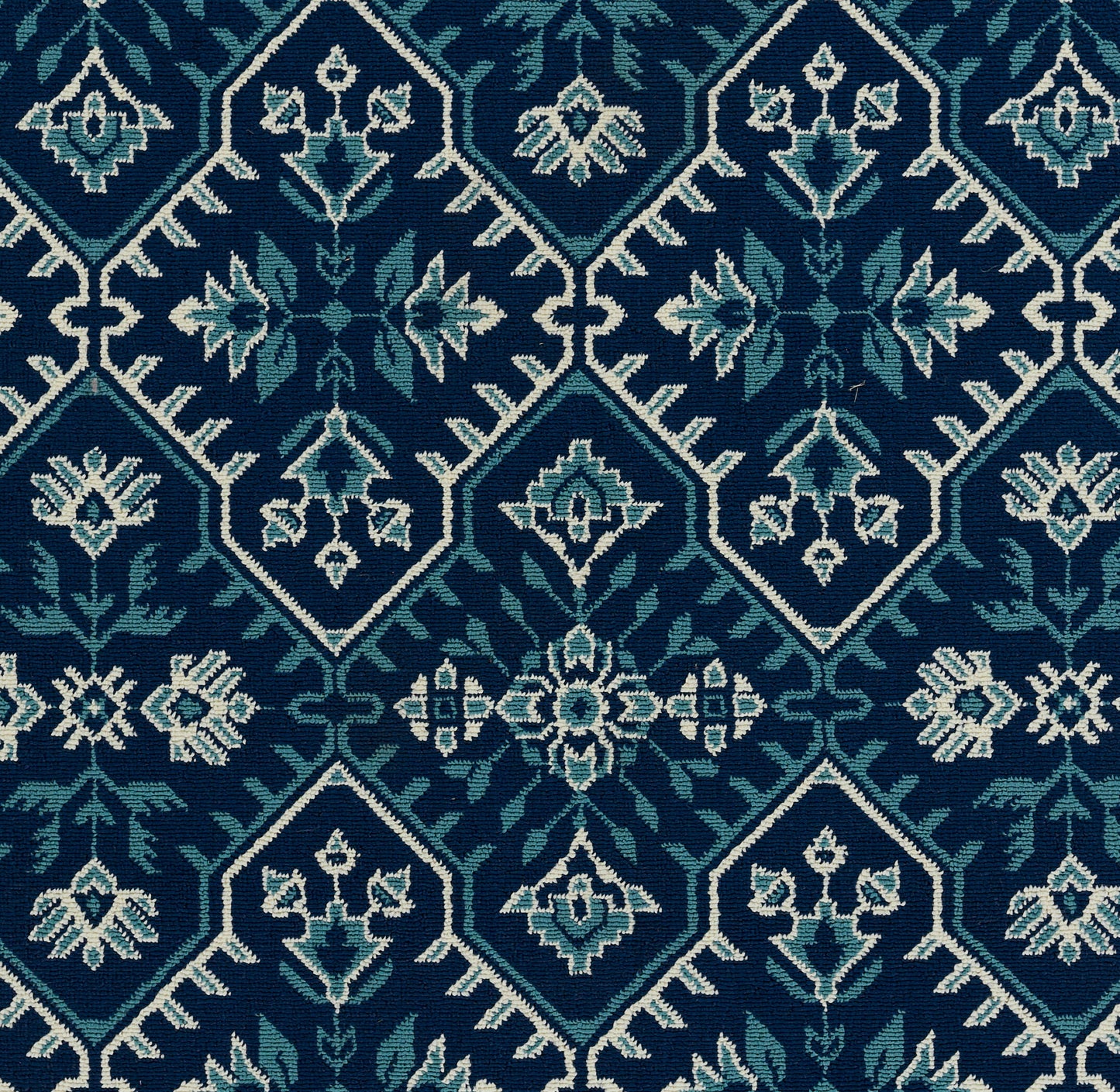 Dark teal & navy rug with white outlined diamond motifs & pale blue floral accents in a repeating geometric pattern.