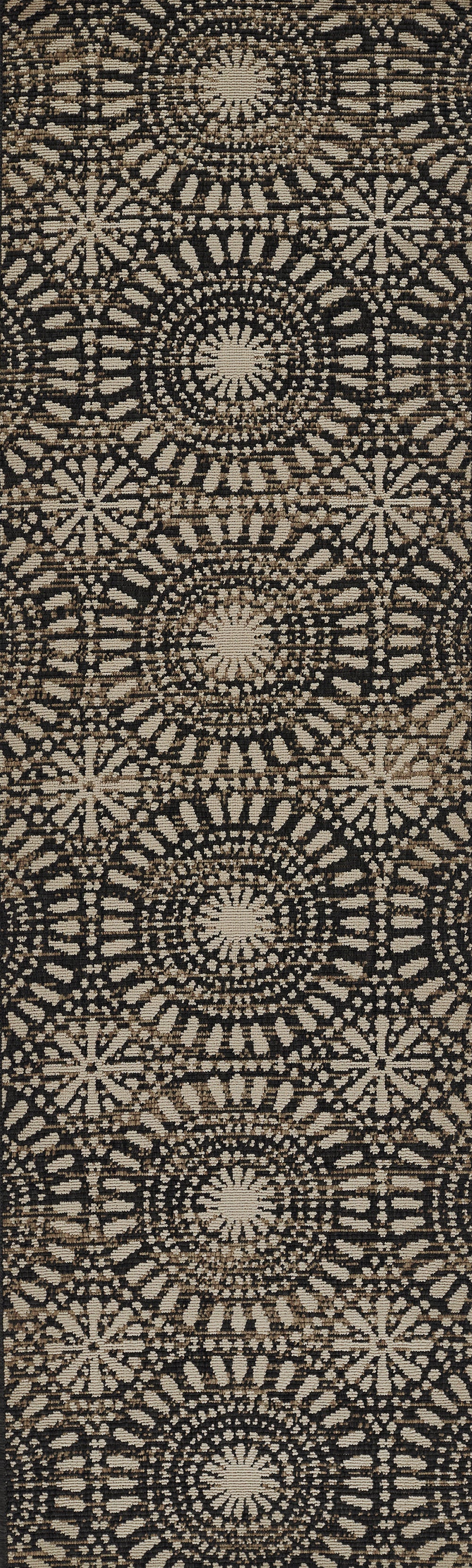 Beige circular mandala rosette pattern on black woven fabric rug & repeating boho motif.