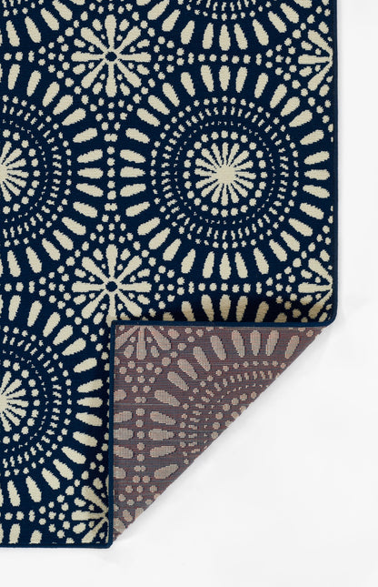 Navy blue rug with cream circular mandala motifs; folded corner shows brown underside.