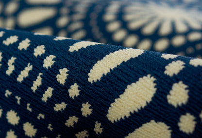 Close-up of navy blue woven throw with ivory geometric dot motif and textured weave.