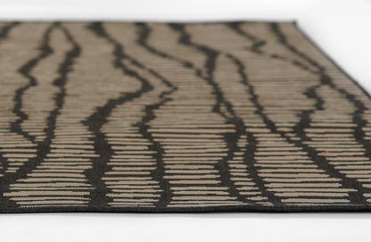 Rectangular Baja-style rug: beige background with bold black zebra-like wavy stripes, low-pile woven texture.