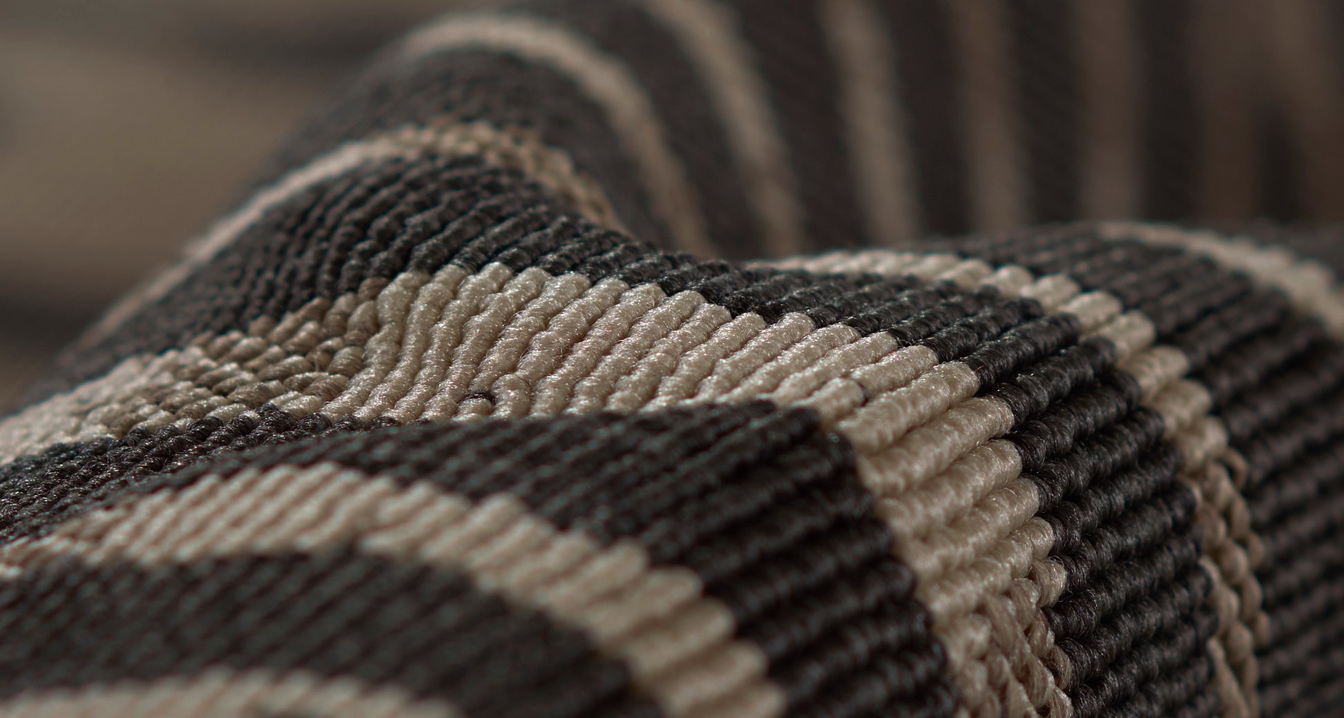 Close-up of brown and beige striped woven rug with a ribbed texture, 2' x 4'.