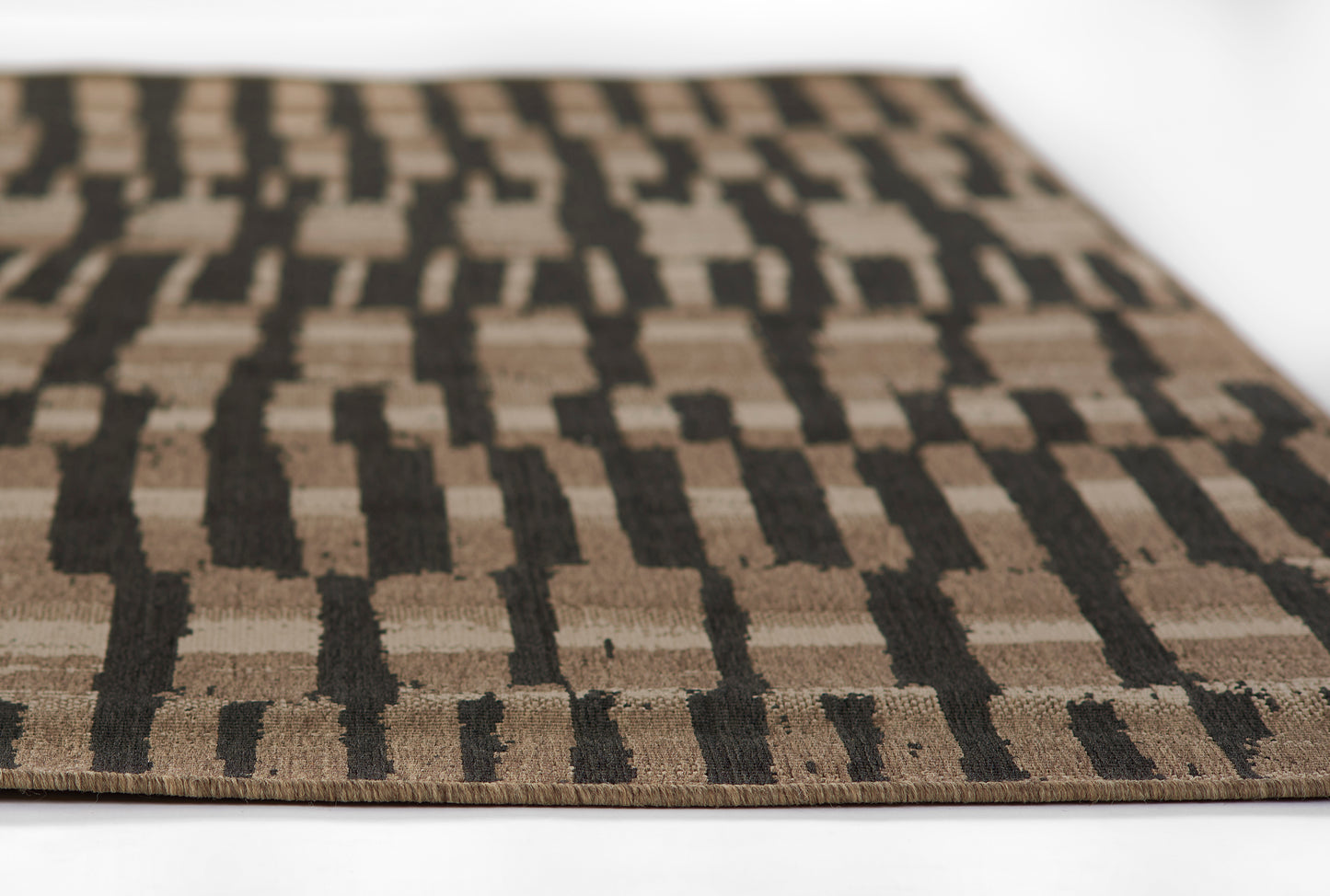 Brown and tan geometric Baja rug with black linear motifs, woven texture, close-up edge view.