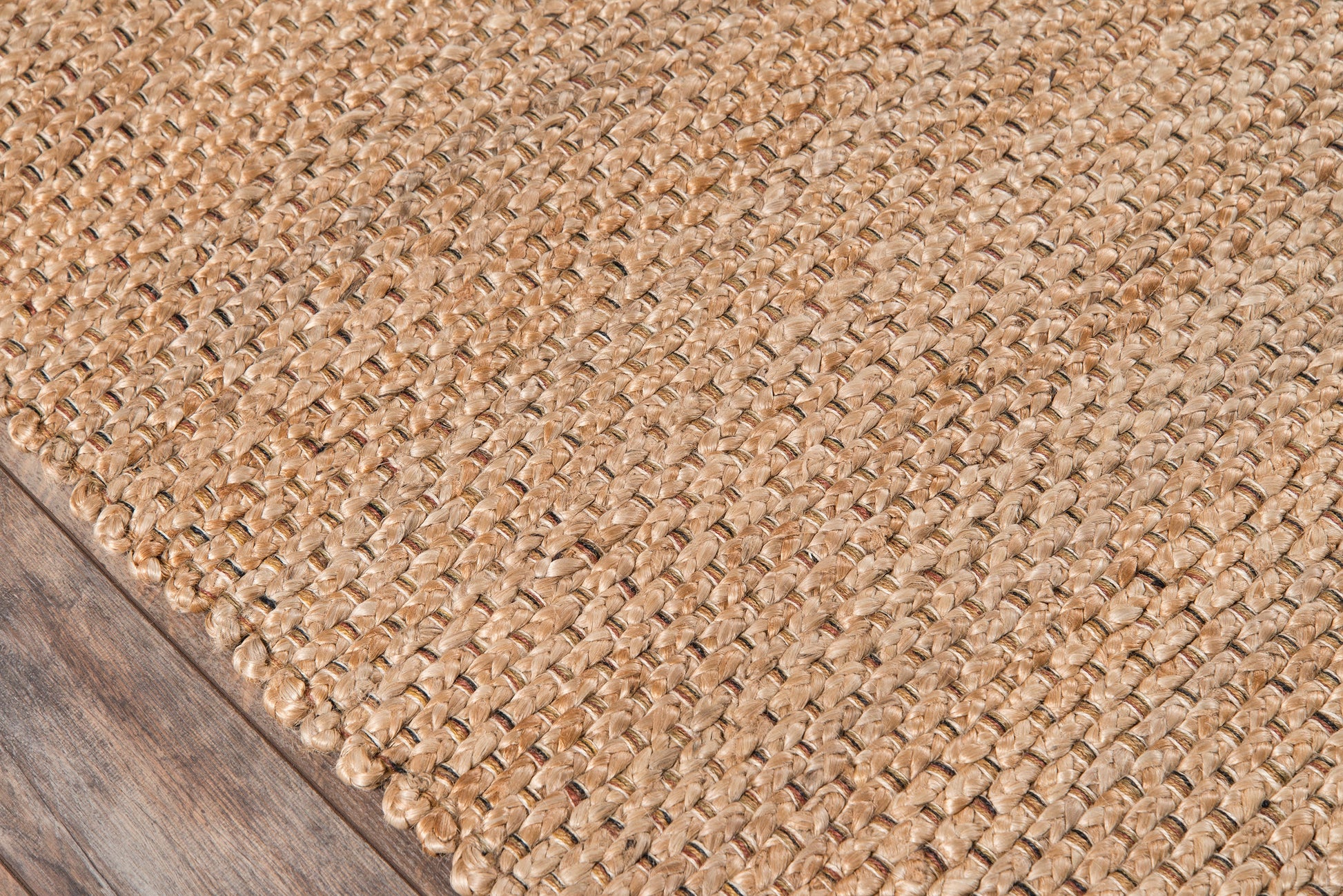 Natural beige jute rug with braided weave on wooden floor.
