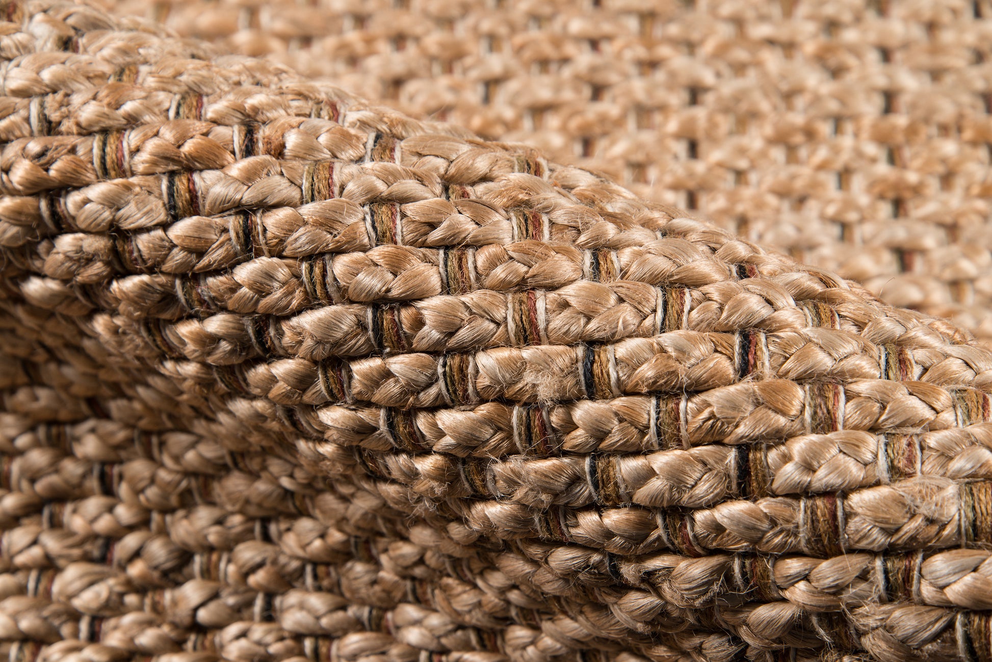 Natural braided jute weave in light tan with subtle dark stripes; rustic coastal style.