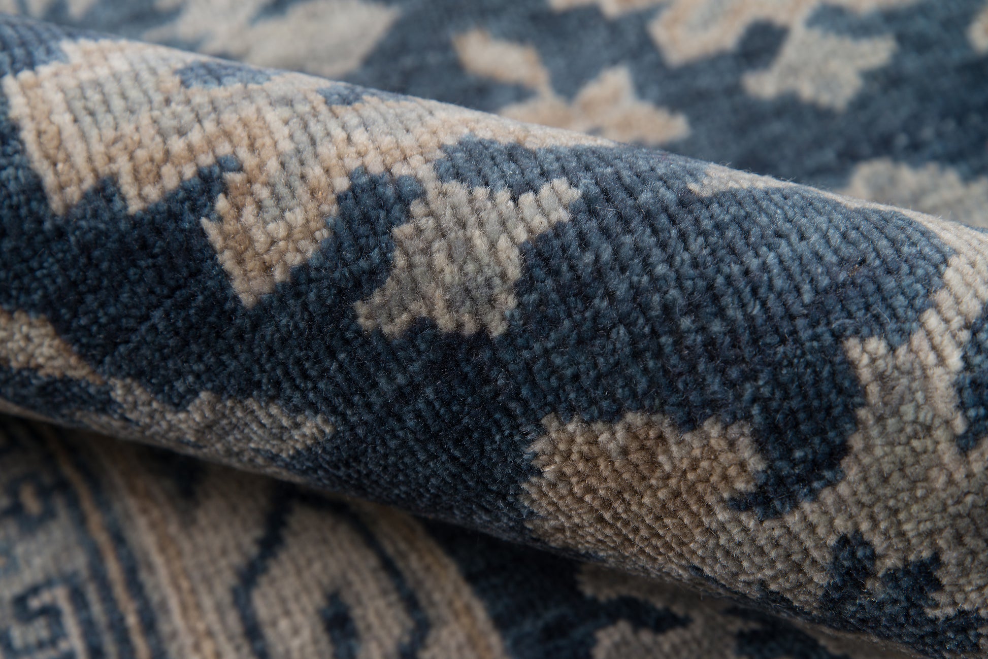 Blue and beige geometric patterned rug with a soft woven texture, close-up.