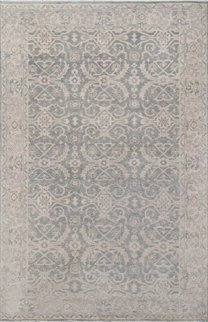 Blue-gray oriental area rug with ivory floral arabesque motifs and a decorative border.
