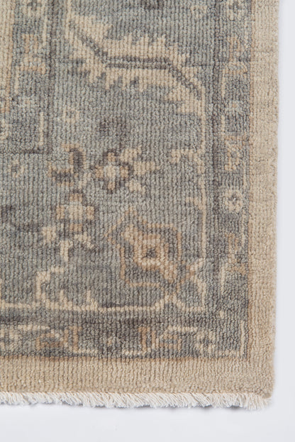 Fringed-edge beige rug with gray-blue arabesque border and cream highlights; soft tufted pile.
