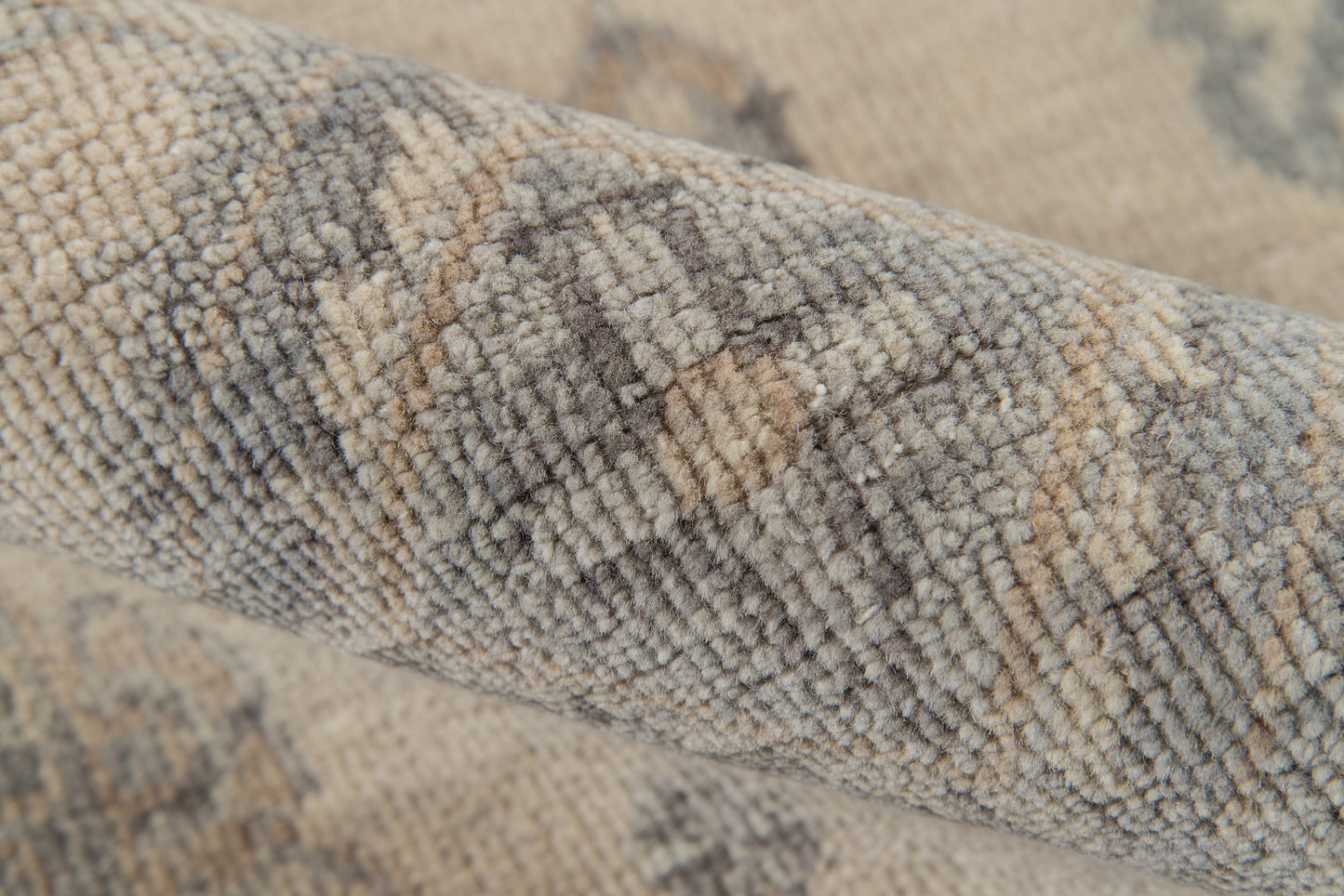 Close-up of a plush gray beige rug with dense loop pile and subtle abstract pattern.