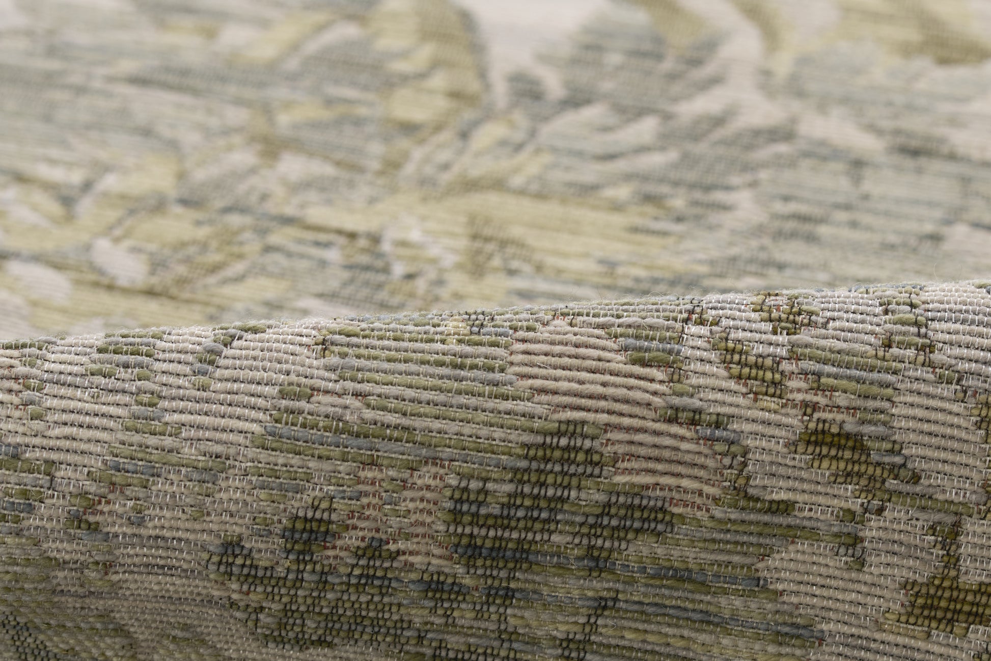 Muted olive, beige and cream floral tapestry weave; woven rug texture with folded edge.