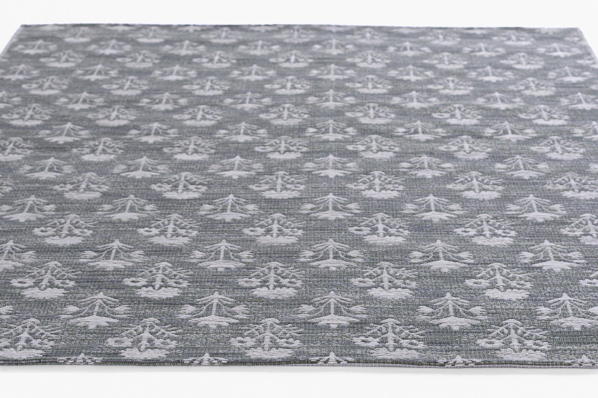 Gray textured woven rug with a white repeating geometric motif, modern rectangular decor.