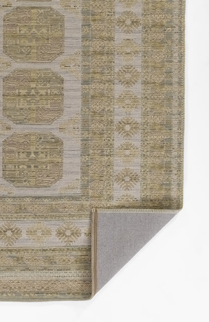 Beige and taupe patterned area rug with geometric medallions, borders, woven texture; folded corner reveals gray backing.