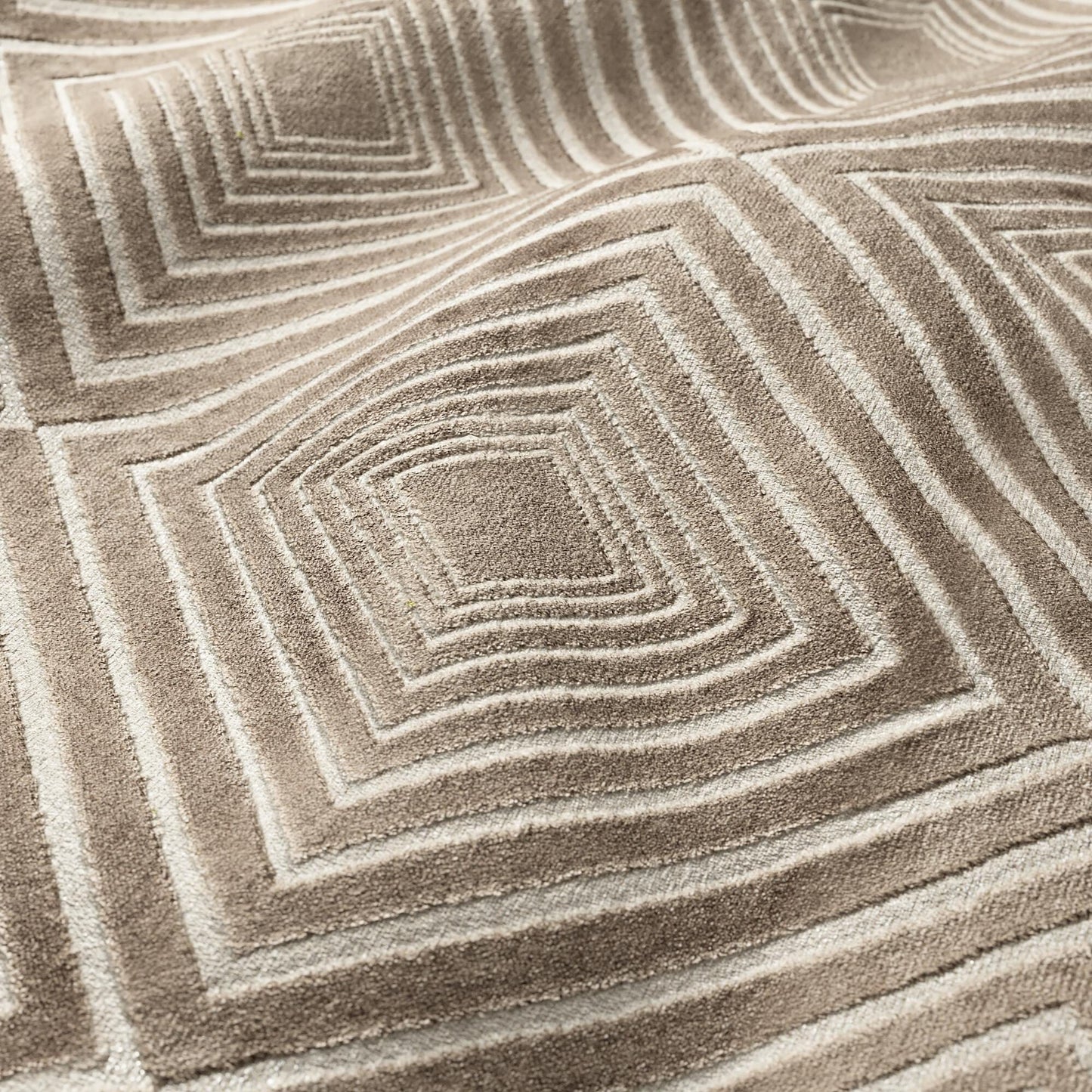 Taupe velvet fabric with a geometric diamond pattern; soft, luxurious textile.