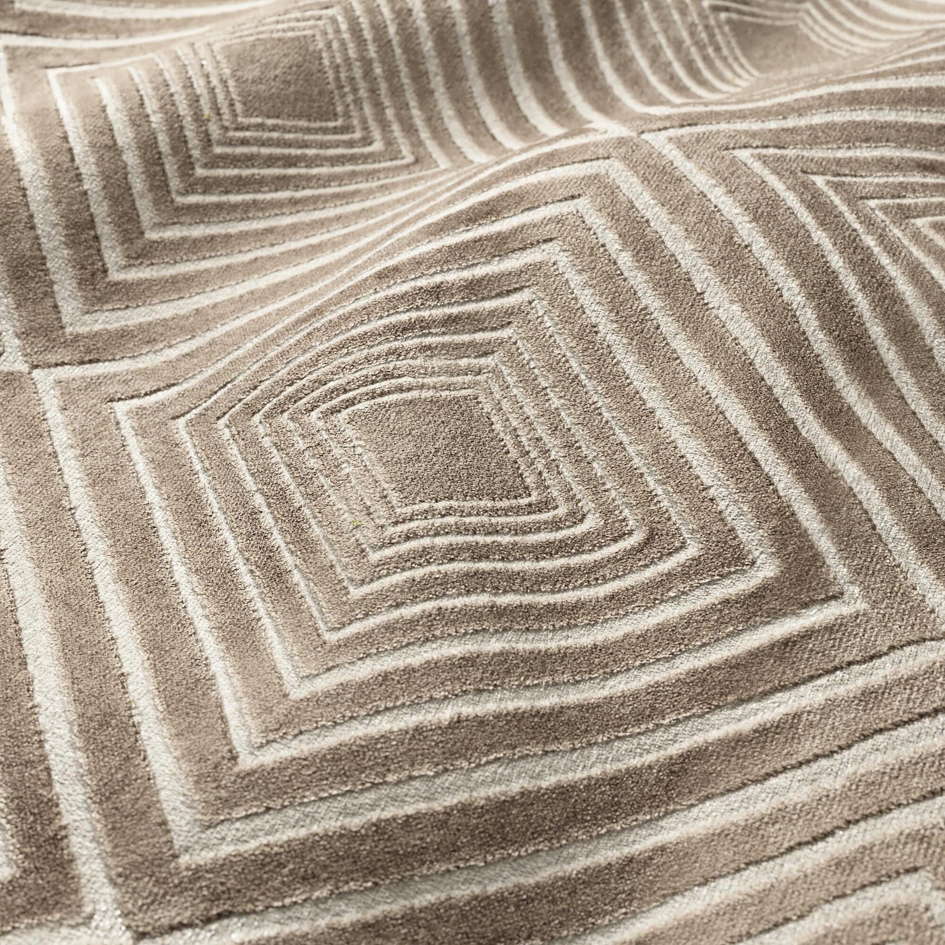 Taupe velvet fabric with a geometric diamond pattern; soft, luxurious textile.