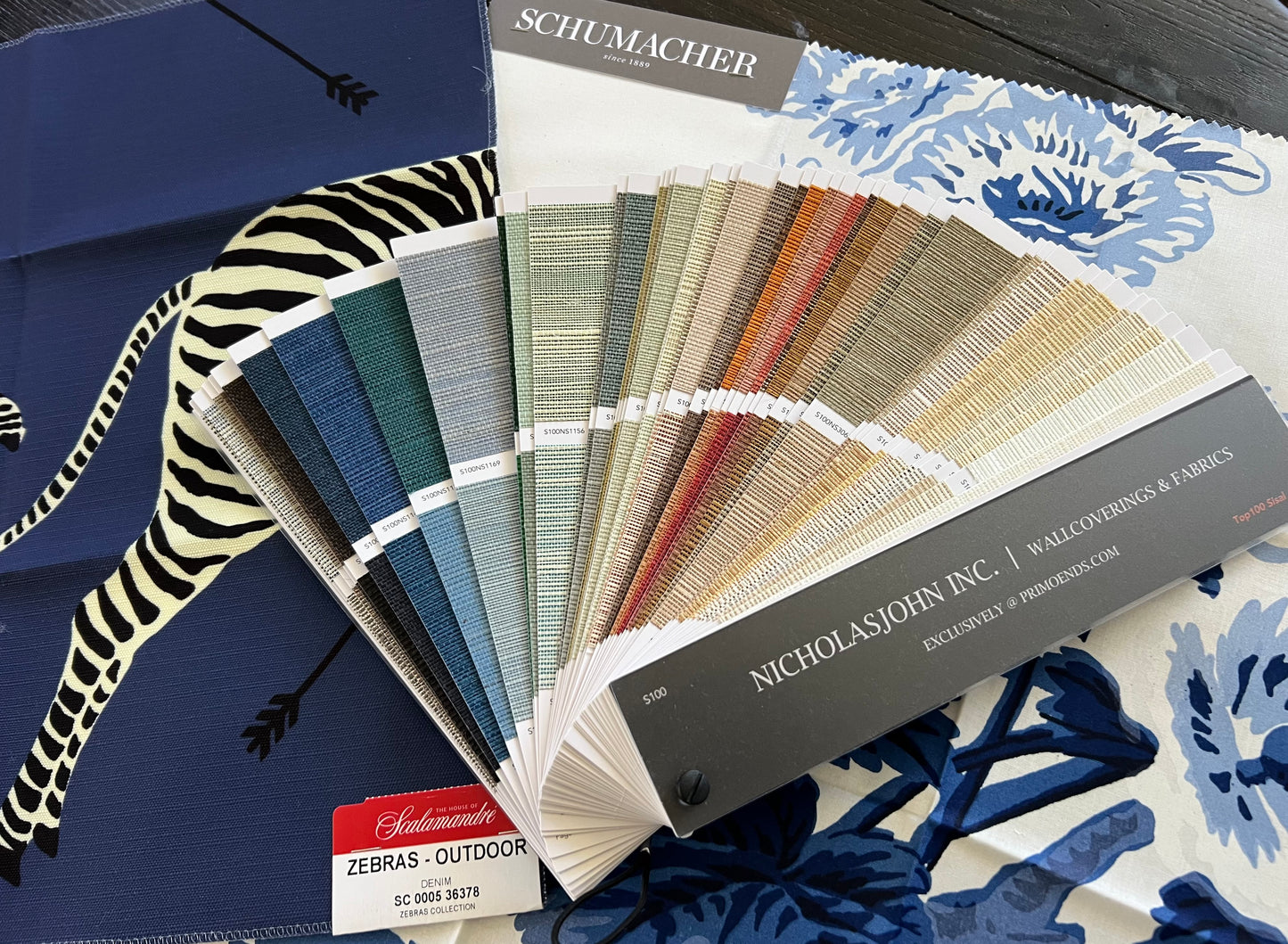 Fabric swatch book with design samples on a blue background