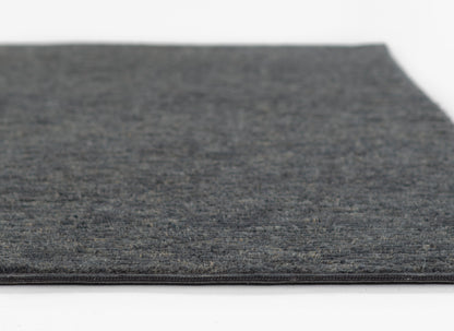 Charcoal grey textured rug with soft low-pile and bound edge; rectangular, modern home decor piece.