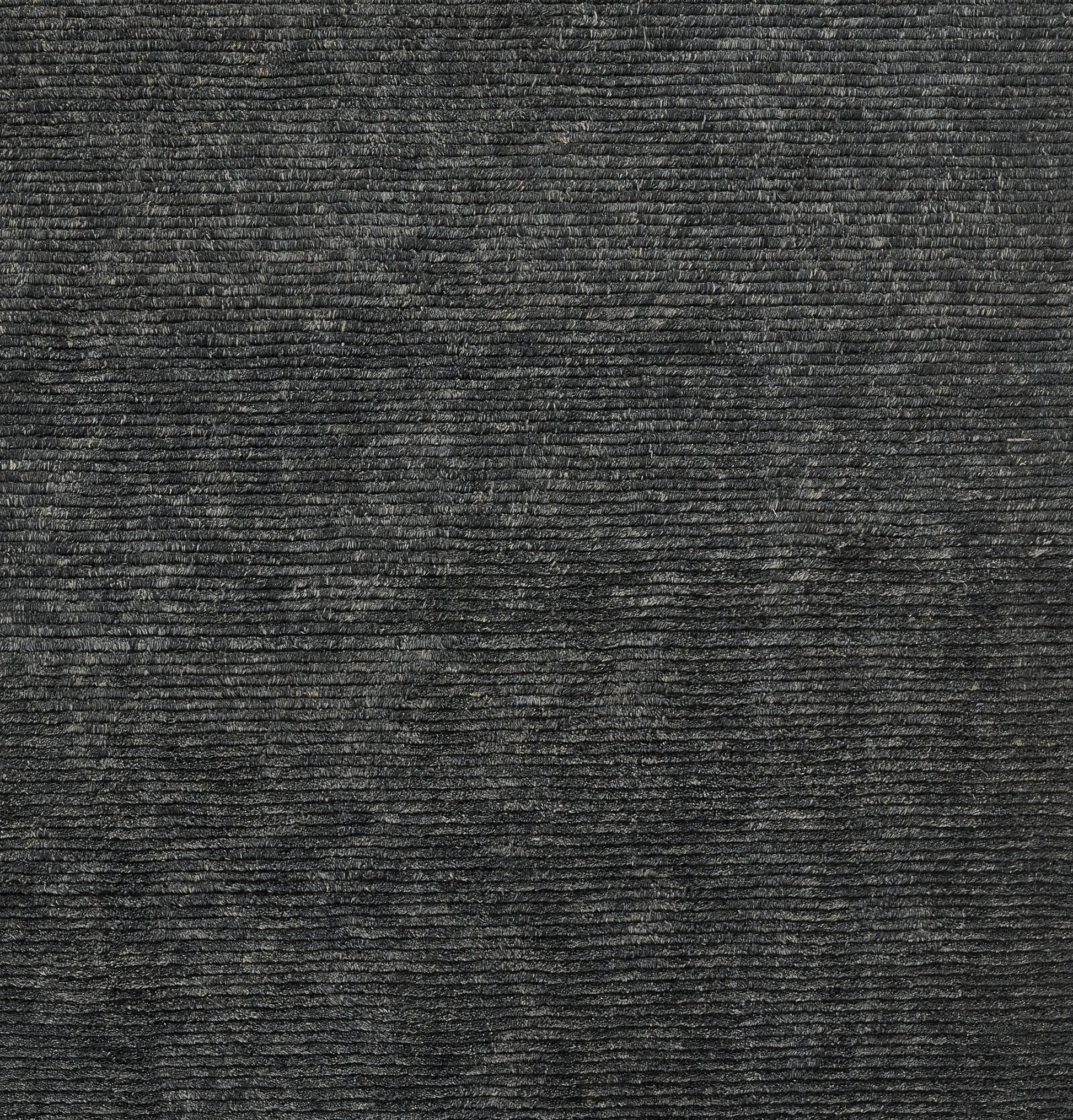 Dark charcoal ribbed fabric texture with horizontal ridges; corduroy-like upholstery or rug material.