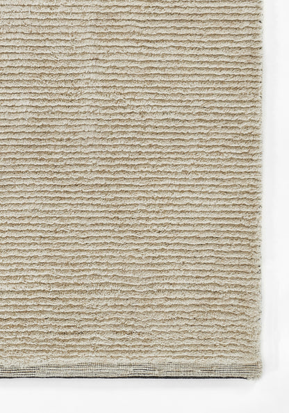 Beige loop-pile rug with ribbed texture and woven border, rectangular floor covering for living spaces.