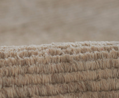 Beige loop-pile rug edge with thick soft fibers; natural woven texture for cozy neutral decor.