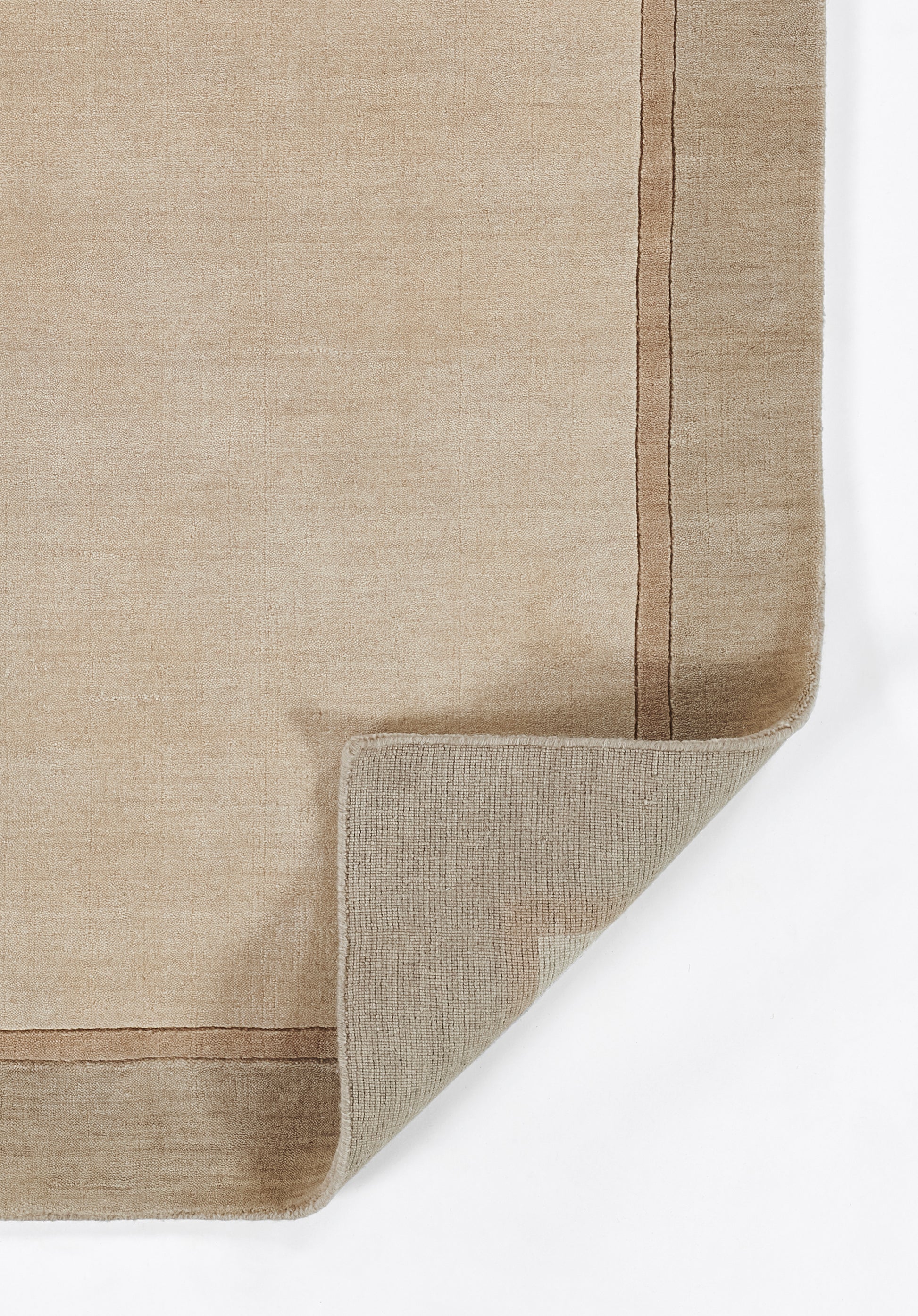 Beige taupe flatweave rug with a double border, natural textured weave, corner folded to show underside.